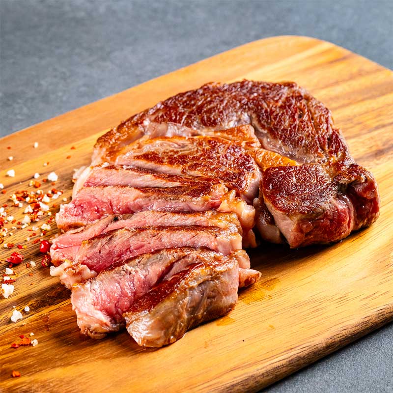 Medium Rare gegrilltes Premium Black Angus Ribeye Steak von TAURBULL, rosa Kern, zarter Biss, vollendete Marmorierung.