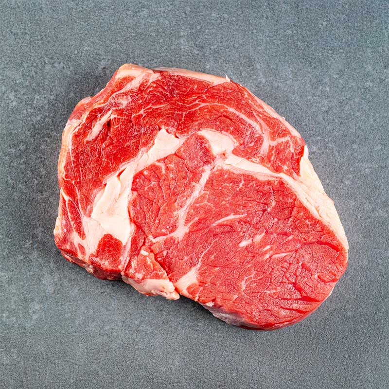 Premium Black Angus Ribeye Steak von TAURBULL, roh, von oben aufgenommen, zeigt perfekte Marmorierung und rotes Fleisch