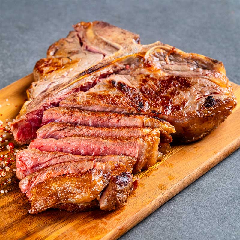 Gegrilltes Premium Black Angus T-Bone Steak von TAURBULL, saftig und mit intensiver Röstaromatik, aufgeschnitten.