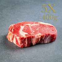 Ribeye-Steak, rohes Fleisch auf grauer Oberfläche, 5X 400g-Beschriftung oben rechts.