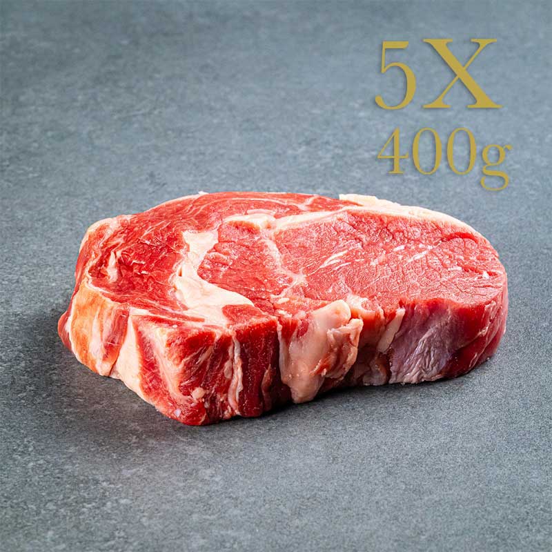 Ribeye-Steak, rohes Fleisch auf grauer Oberfläche, 5X 400g-Beschriftung oben rechts.