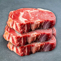 Mehrere rohe Rindersteaks mit Knochen auf grauem Hintergrund.